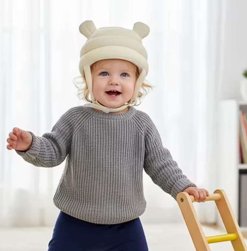 Toddler wearing the cream LittleTumble HeadGuard