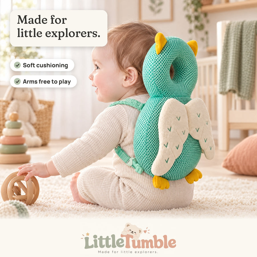 Baby sitting on a rug wearing the owl LittleTumble Backpack