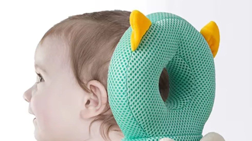 Side view of a baby wearing the owl Backpack, arms free